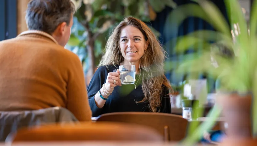 Twee mensen zitten tegen over elkaar te praten