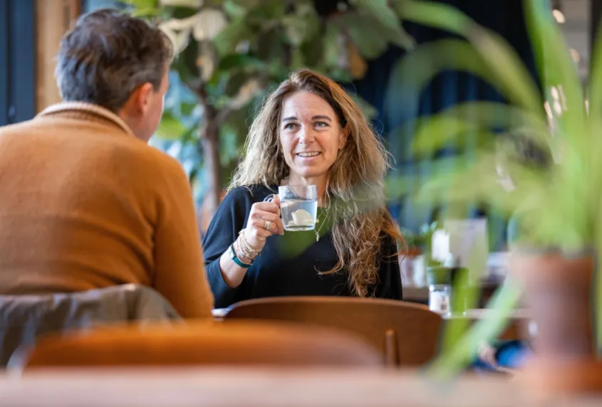 Twee mensen zitten tegen over elkaar te praten